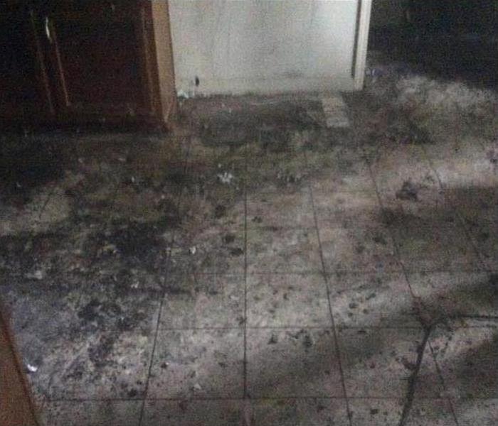 material removed, showing dirty tile floor covered in soot.