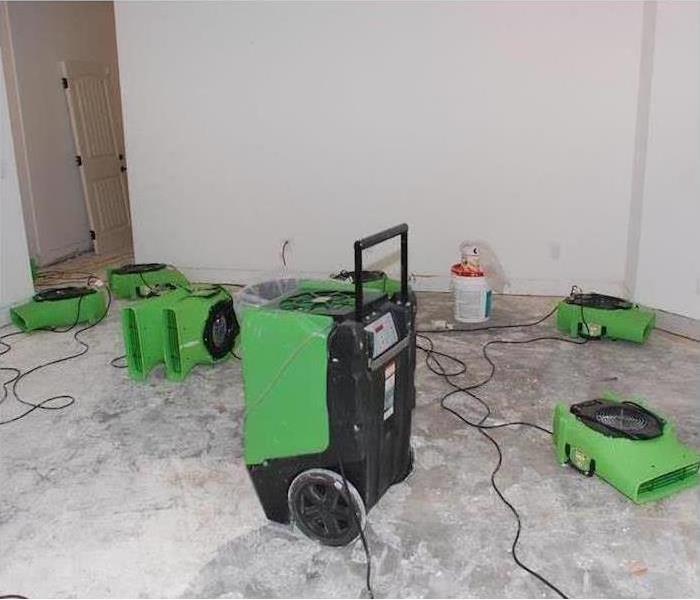 LGR dehu and air movers drying bare concrete pad, grayish walls